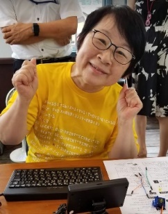 Ms. Midori Miyoshi in a yellow T-shirt.